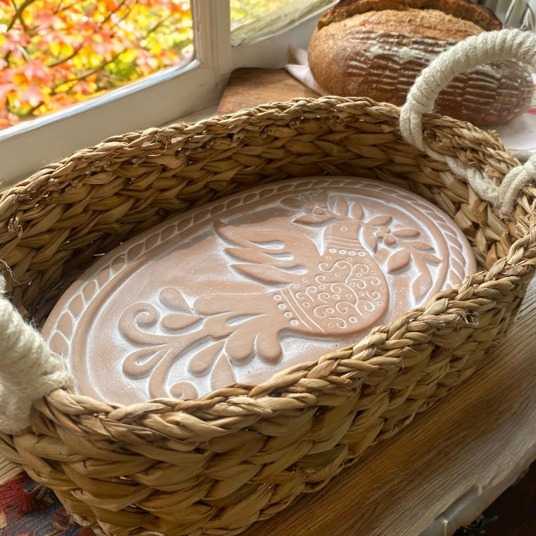 Eco-friendly terracotta bread warmer for autumn baking, featured in a warm, rustic kitchen with fall leaves and harvest accents.