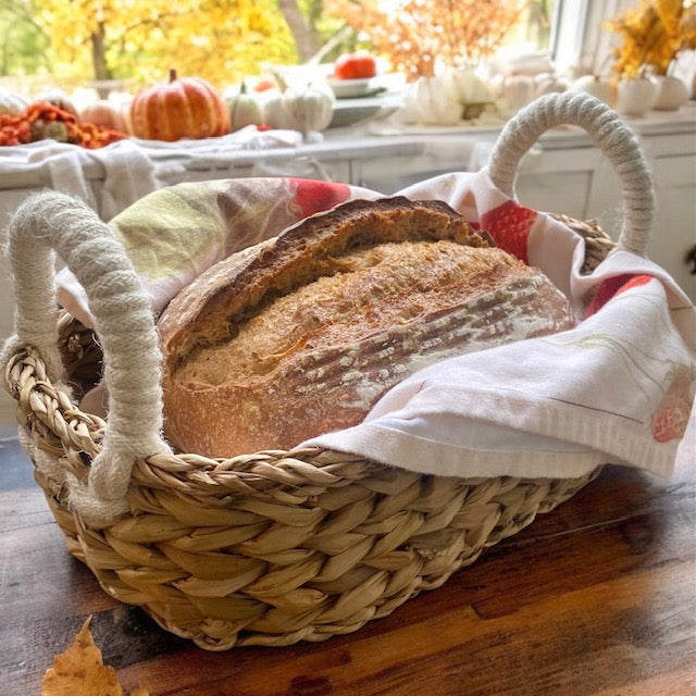 Artisan terracotta bread warmer in a cozy fall kitchen, surrounded by pumpkins, cinnamon sticks, and warm seasonal decor.