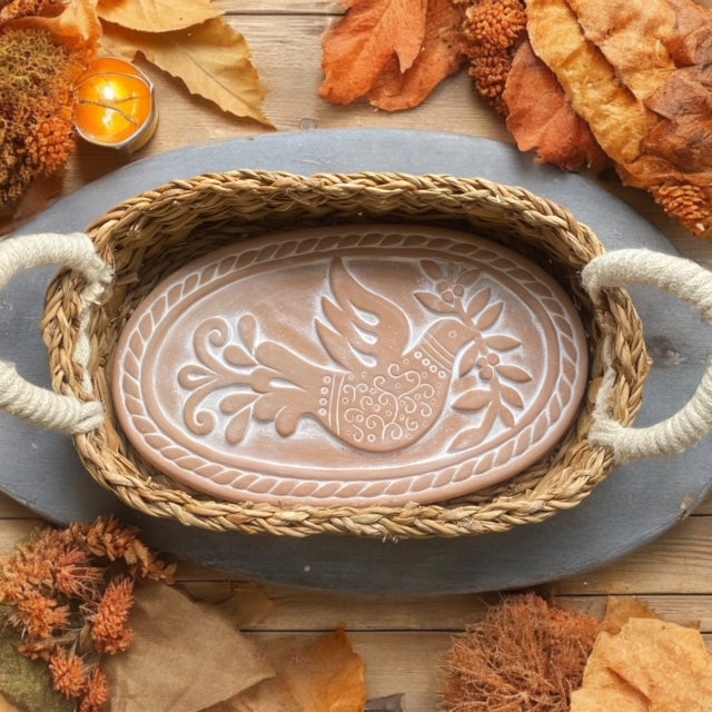 Artisan terracotta bread warmer in a cozy fall kitchen, surrounded by pumpkins, cinnamon sticks, and warm seasonal decor.